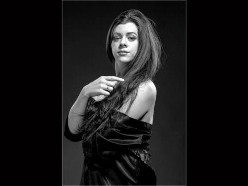 Rhianna 1  20.5  Pictorial  Silver  Ted  Buck  It would be a nice portrait, but the skin appears to be very rough...specially on the face. Leave more room on the right...seems a bit crowded that side.The image of the model has impact, is sharp, well exposed, and well lit, highlighting the model's hair.  The positioning of the model is very tight on the left side, perhaps a wider crop would enhance the image.  Good use of a border.